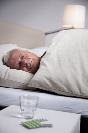 pills beside a senior mans bed