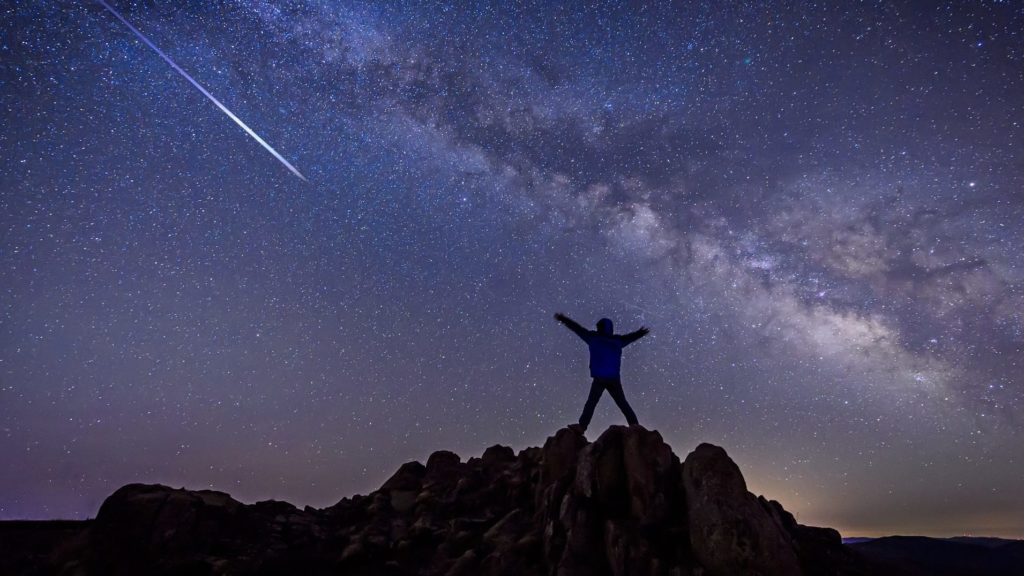 Starseed looking at shooting star under Milky Way Galaxy